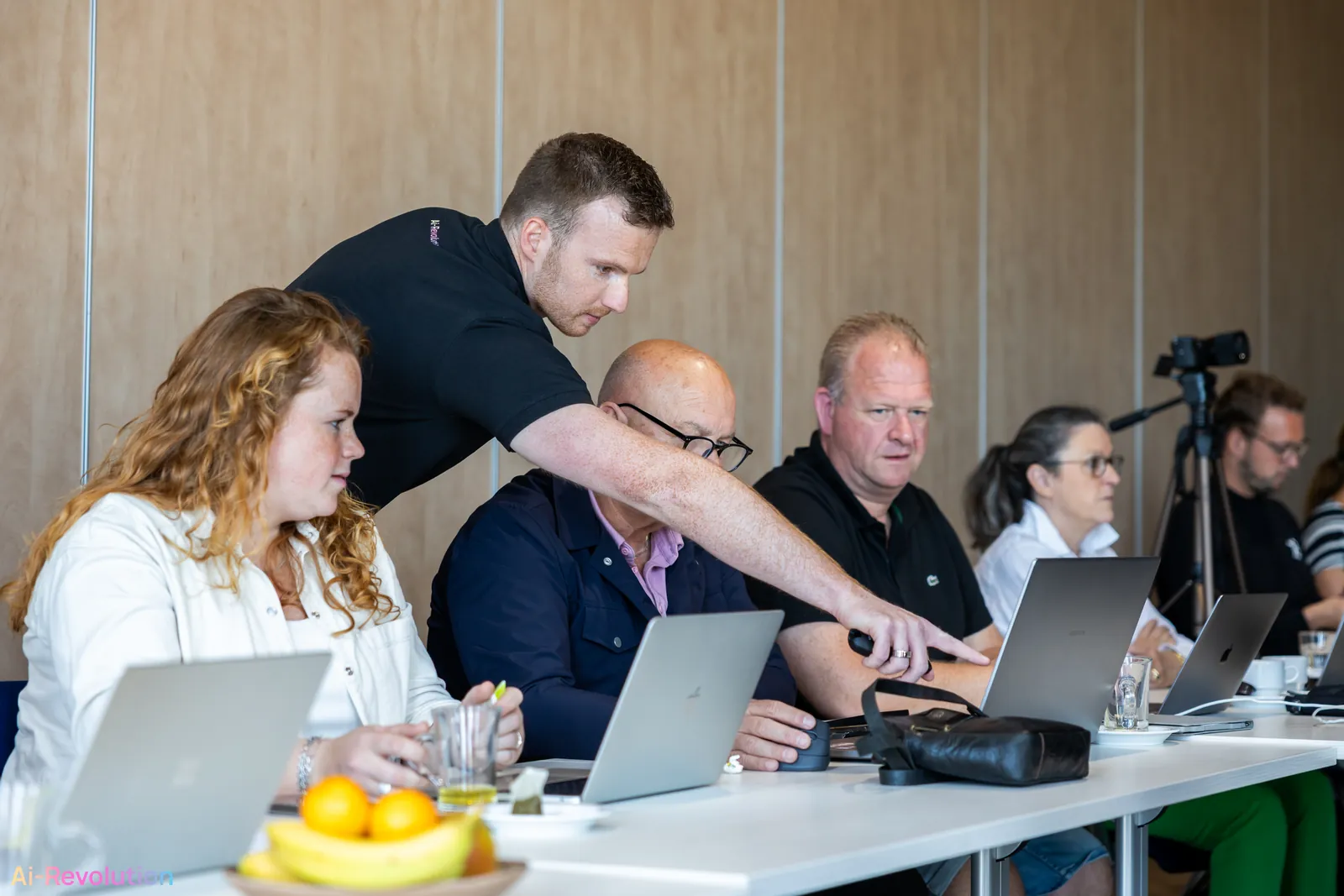 Mika geeft in-company Ai-Training aan een team met laptops