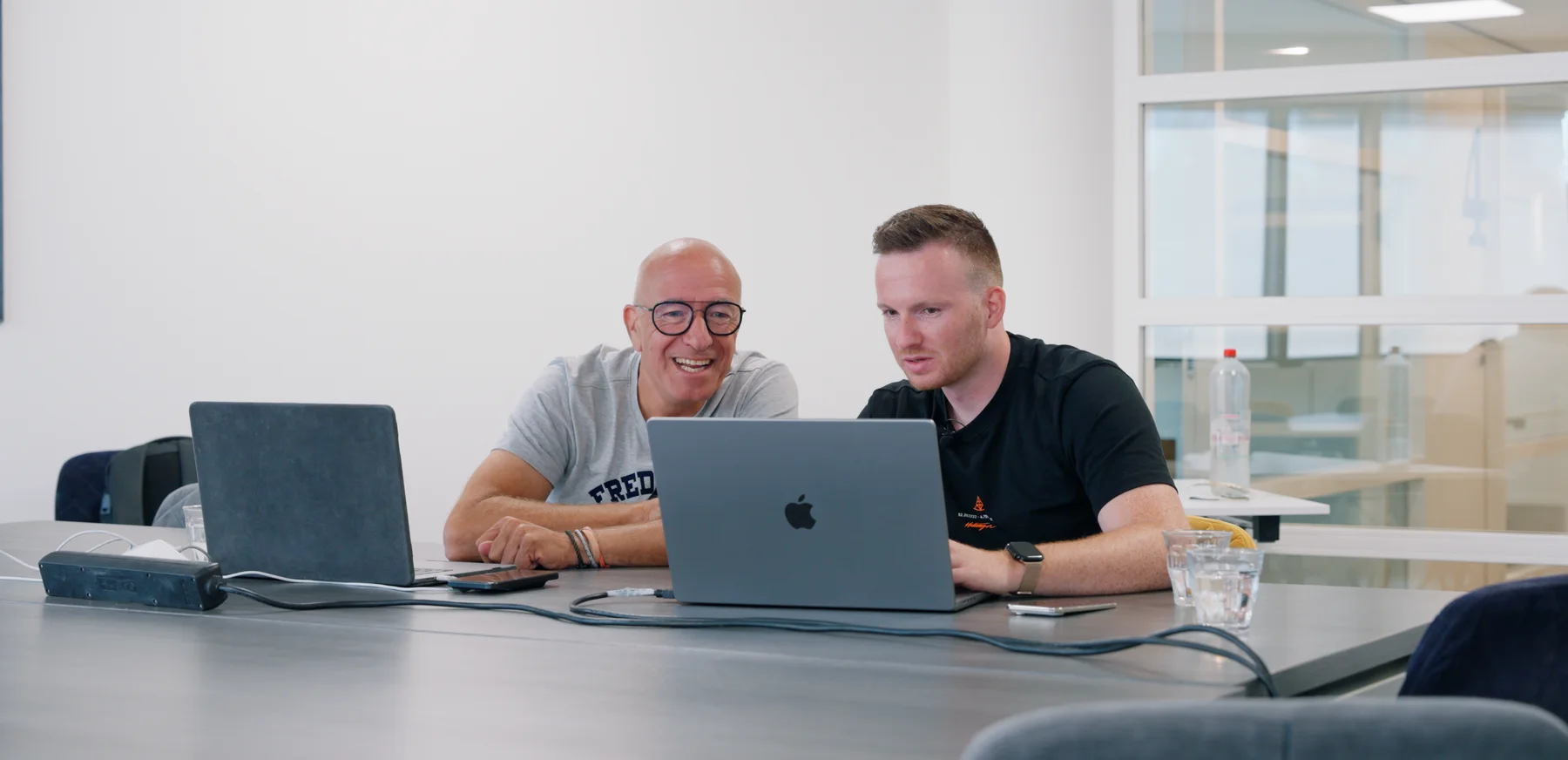 Mika Karthe en Tim Coronel achter een laptop tijdens de sessie waarin de nieuwe website werd gebouwd.
